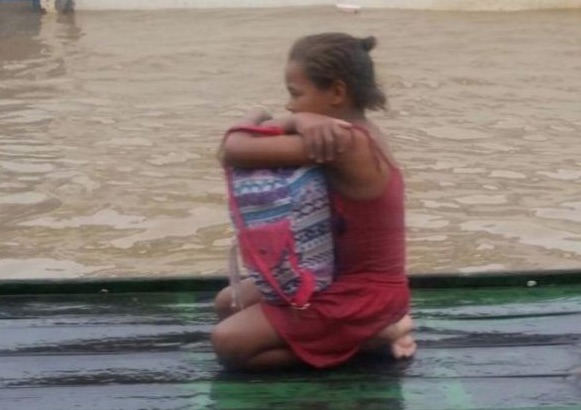 Menina salva livros enchente